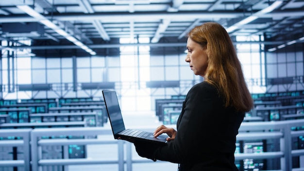 System administrator in server farm using laptop to patch network issues