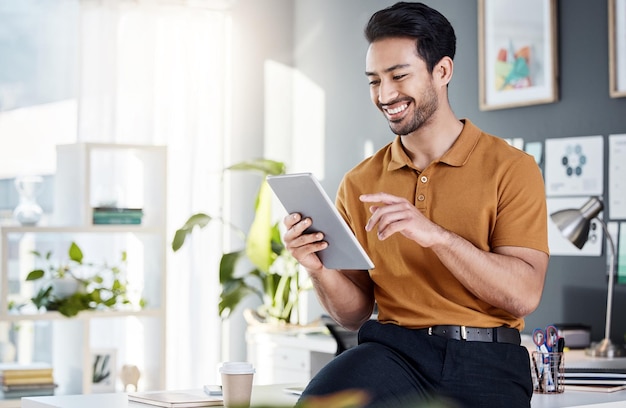 Tablet office and happy man with online software website design or data results review or feedback for tech company Creative asian person analyst or employee on digital technology or application