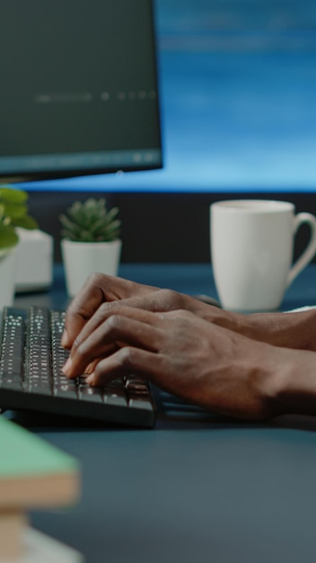 Tæt på sorte hænder, der koder servergrænseflade med binære koder på computer. Afrikansk amerikansk koder programmering af webstedets firewall til beskyttelse og softwareudvikling. Webprogrammerer