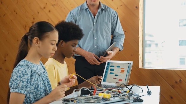 teacher standing while explain coding and robotic construction edification
