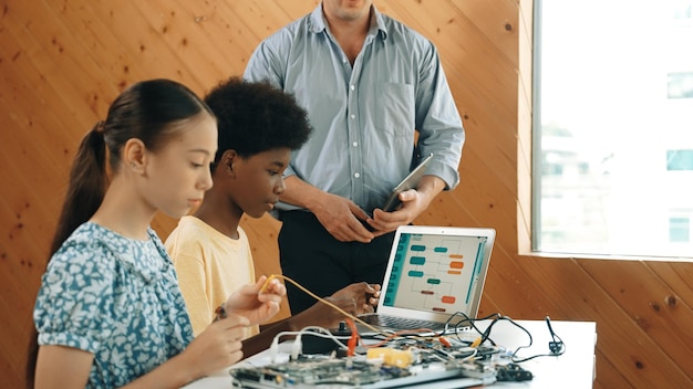 teacher standing while explain coding and robotic construction edification