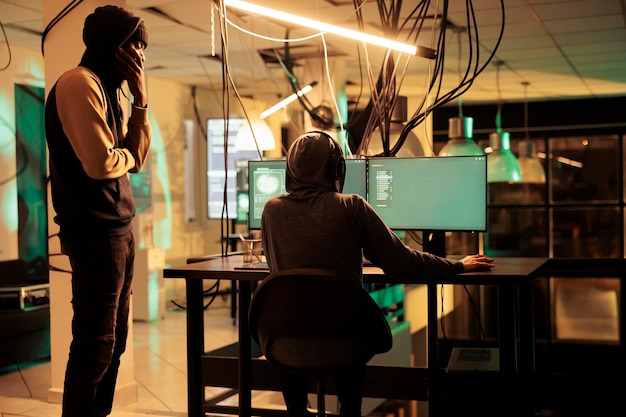 Team of thieves stealing passwords and cracking account having access to important sensitive information on multiple monitors Spies hacking network system working on identity theft