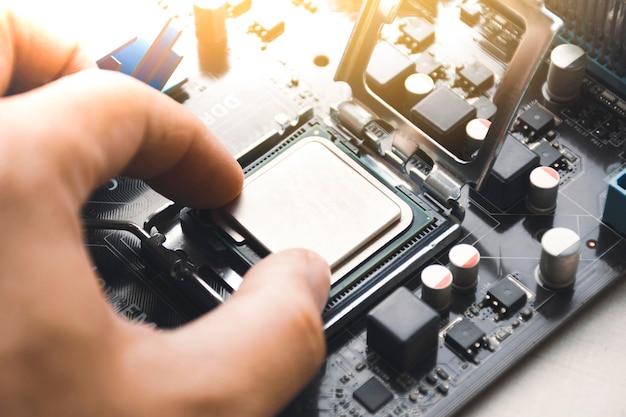 technician install cpu processor chip in socket on computer motherboard
