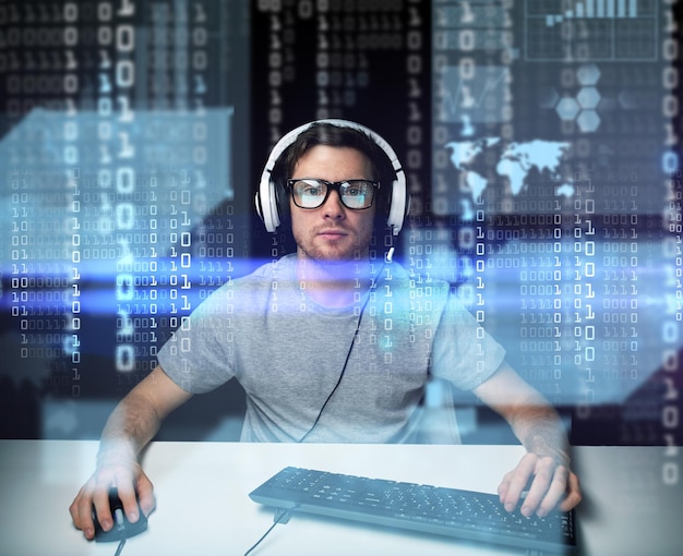 technology, cyberspace, virtual reality and people concept - man or hacker in headset and eyeglasses with keyboard hacking computer system or programming over binary code projection
