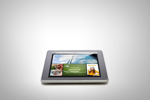 technology, internet, mass media and modern gadget concept - close up of tablet pc computer with news application on screen over gray background