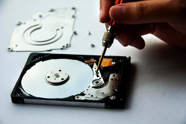 The abstract image of inside of hard disk drive with technician fixing using screw driver