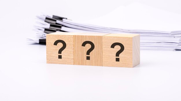 Three wooden cube with question marks on white background
