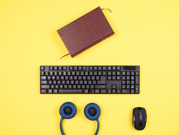 Top view  bussines man concept image on yellow desk, headphones, book