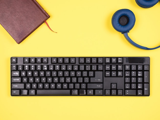 Top view  bussines man concept image on yellow desk, headphones, book