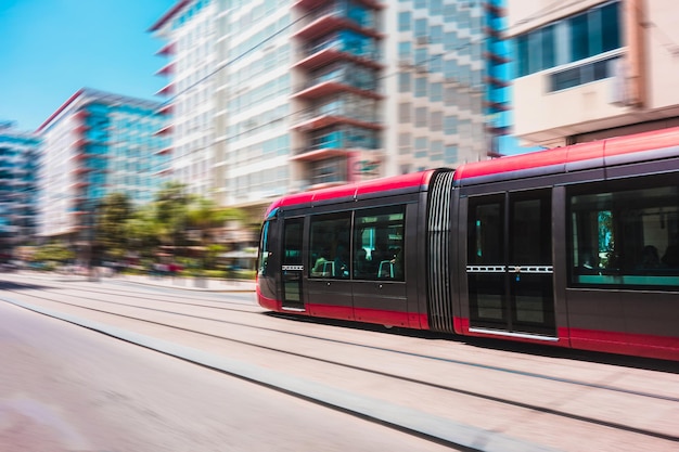 Tramway moving on railroad track against buildings in city