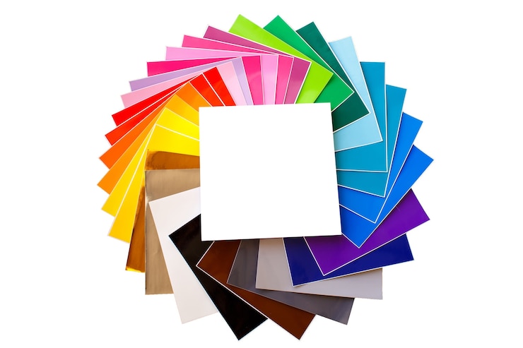 Foto twisted pile of colorful 12x12 sheets of adhesive paper with box isolated over the white background. mockup. assorted colors.