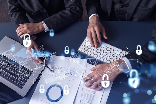Two businesspeople man and woman working on the project to protect cyber security of international company Padlock Hologram icons over the table with documents Formal wear Workspace