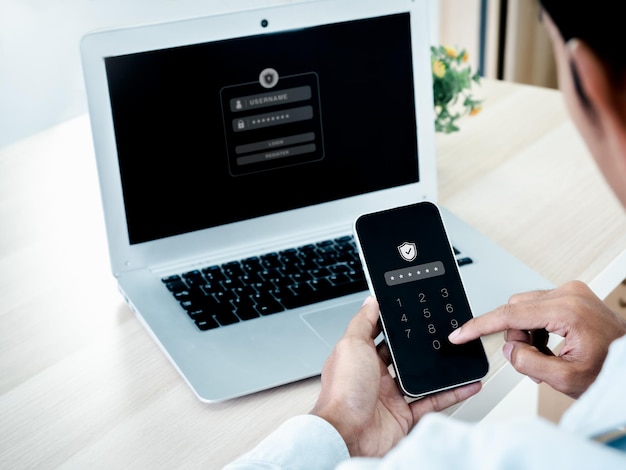 Two factor authentication or 2FA concept Safety shield icon while access on phone with laptop for validate password Identity verification cybersecurity with biometrics authentication technology