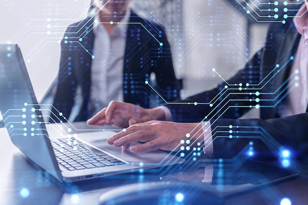 two information technology specialist brainstorming on project to create a new approach to develop software to improve business service working with laptop tech hologram icons formal wear