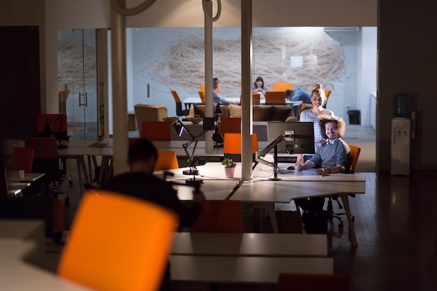 Two young designers are working on a new project in the night office using modern technology