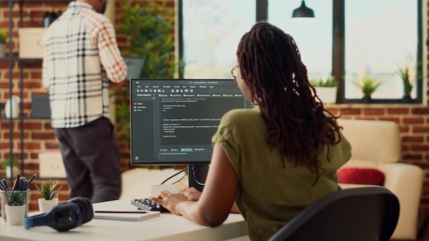 Ung kvinde bruger kildekode til at udvikle ny online app, arbejder med html script på terminalvindue for at programmere databasesoftware. IT-manager planlægger kunstig intelligens netværk.