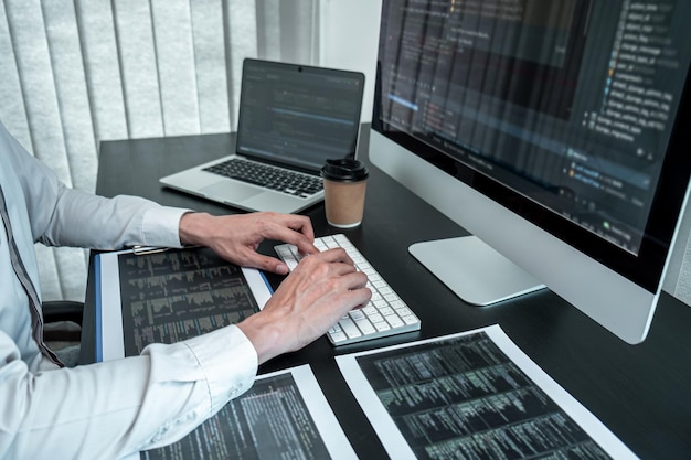 Ung programmør, der arbejder i software javascript computer i IT-kontoret, skriver koder og datakodewebsted og koder databaseteknologier for at finde en løsning på problemet.