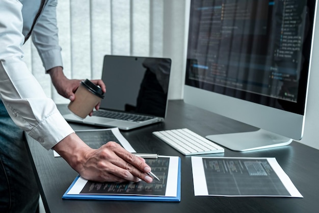 Ung programmør, der arbejder i software javascript computer i IT-kontoret, skriver koder og datakodewebsted og koder databaseteknologier for at finde en løsning på problemet.
