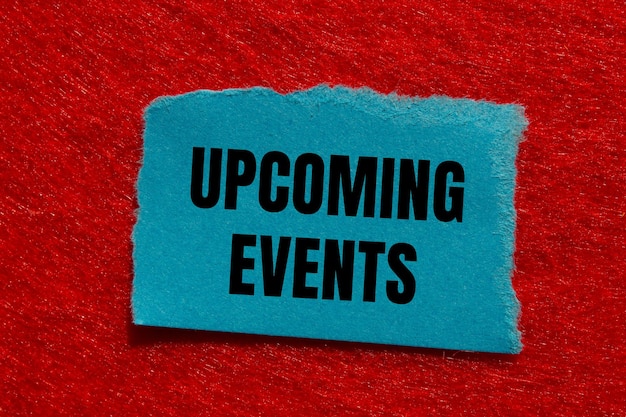 Upcoming events message written on ripped torn blue paper piece with red background Conceptual upcoming events symbol Copy space