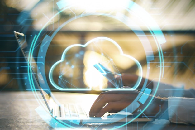 Uploading files to cloud concept Close up of hands using laptop and cellphone with glowing digital cloud with arrow on blurry outdoor background Double exposure