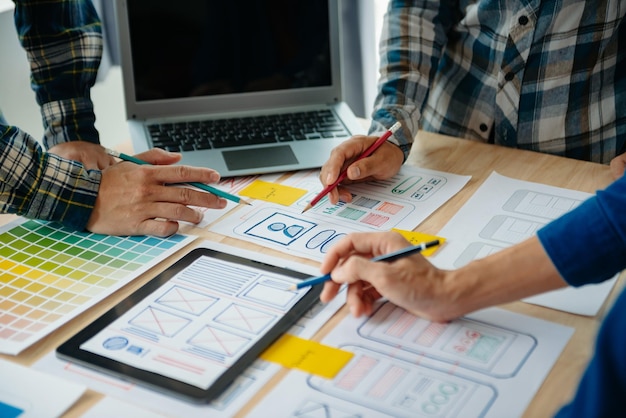UX developer and ui designer brainstorming about mobile app interface wireframe design with customer breif and color code at modern officexA
