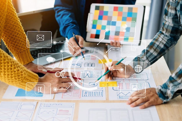 UX developer and ui designer brainstorming about mobile app interface wireframe design with customer breif and color code at office with virtual iconxA