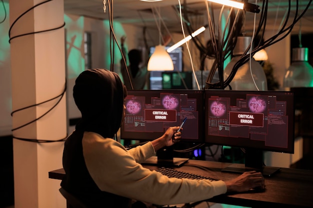 Varningsmeddelande om cyberattack på datorskärm, hackare stjäl lösenord, internetkriminell bryter sig in i databas. Malware-attack, webbvirus, cybersäkerhet, man skriver skadlig programkod