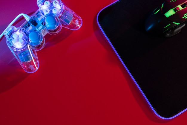view of illuminated neon gaming keyboard setup and controller