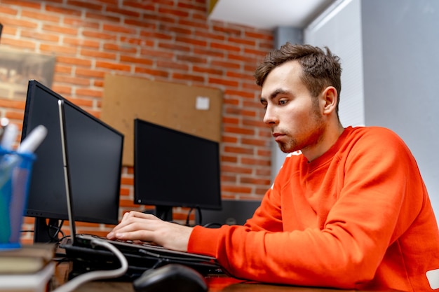 Web programmer near monitor at office in software development company. Website design programming and coding technologies.
