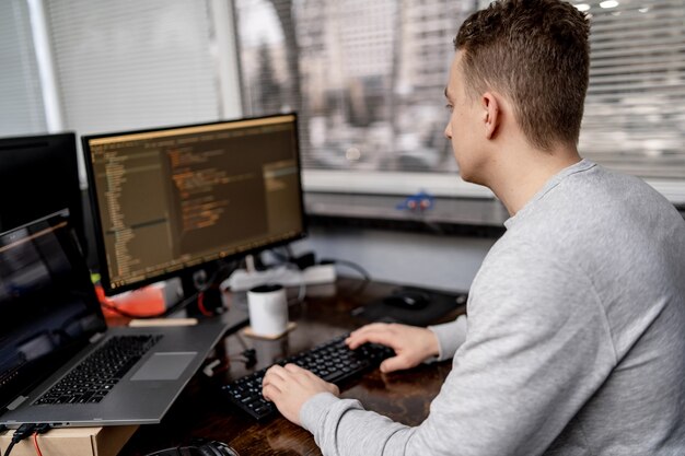 Webbdesign programmering och kodningstekniker. Man på jobbet nära datorn. Kreativt kontor