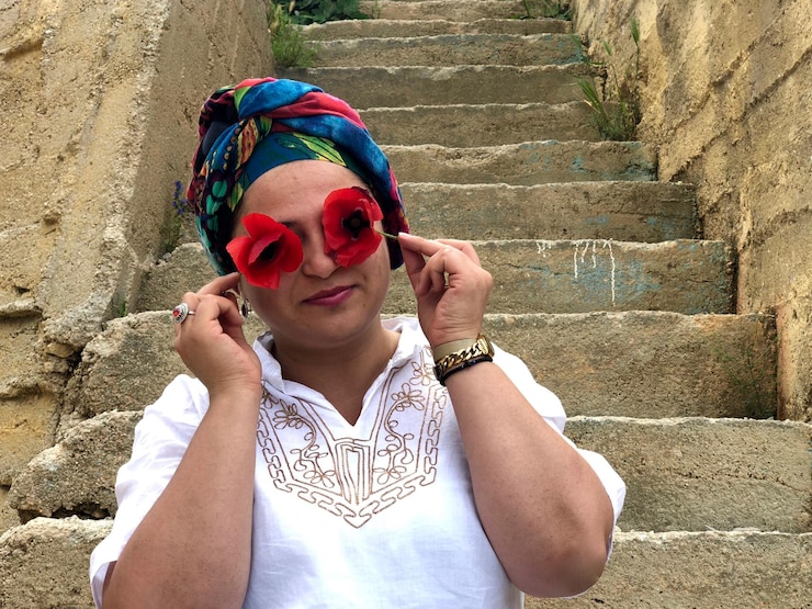 Bild woman covering eyes with flowers against steps