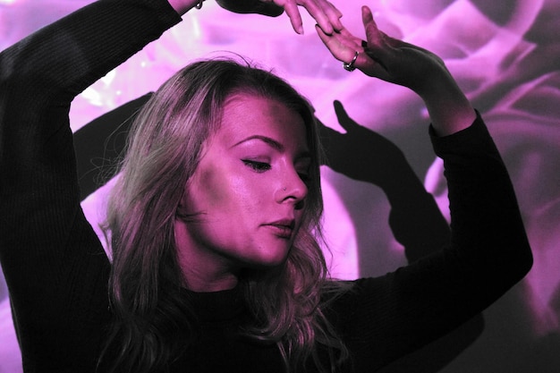 woman dancing against wall at nightclub