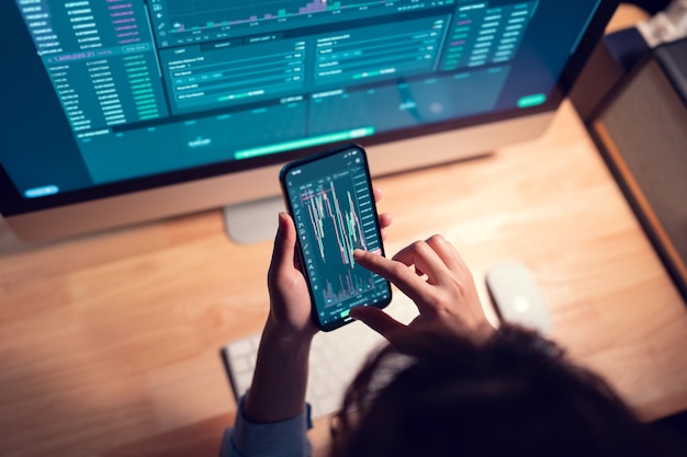 Woman is checking Bitcoin price chart on digital exchange on smartphone