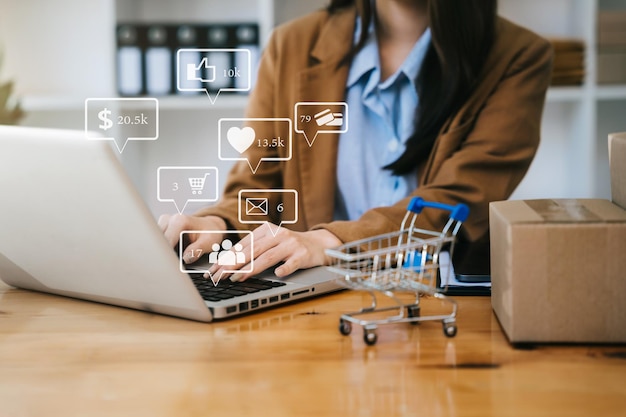 Woman start up small business owner writing address on cardboard box at workplacesmall business entrepreneur SME or freelance asian woman working with box at home