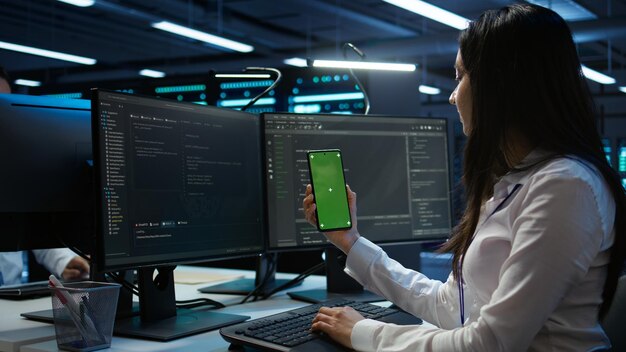 Worker overseeing data center using green screen mobile phone