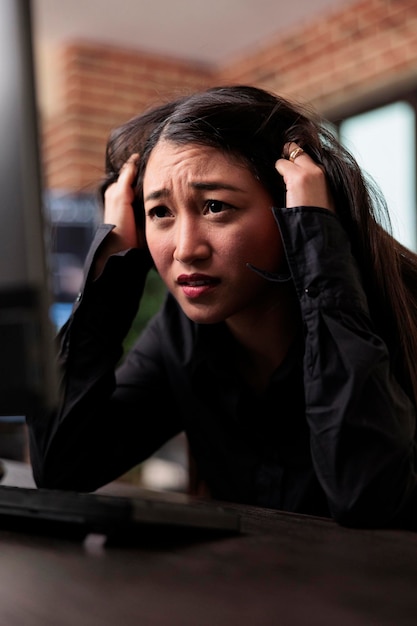 Worried asian network developer failed to create a security protocol for database. Stressed frustrated cybernetics engineer cannot bypass firewall system in order to restore encrypted files stability.