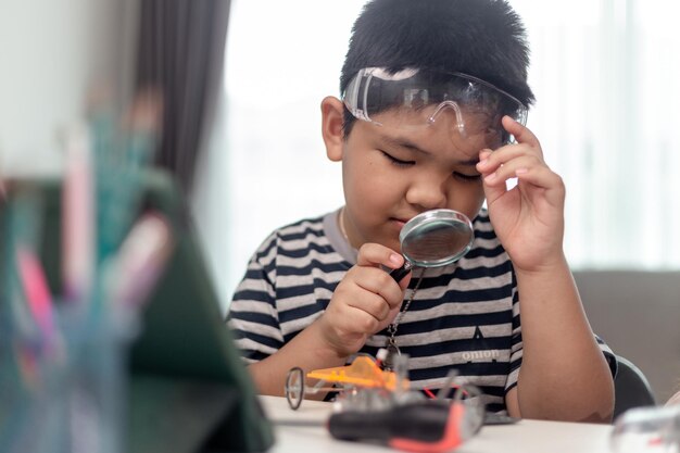 young asia student remotely learn online at home in coding robot car and electronic board cable in stem steam mathematics engineer science technology computer code in robotics for kids