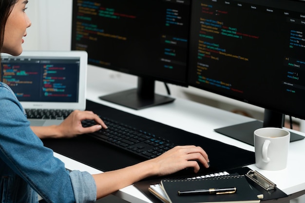 Young asian in it creating with typing online information on pc stratagem