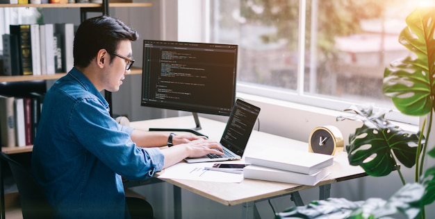 Young Asian programmer working at office
