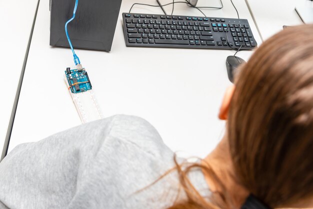 Young caucasian student remotely learn onlinecoding robot car and electronic board cable in STEM STEAM mathematics engineering science technology computer code in robotics for teenage concept