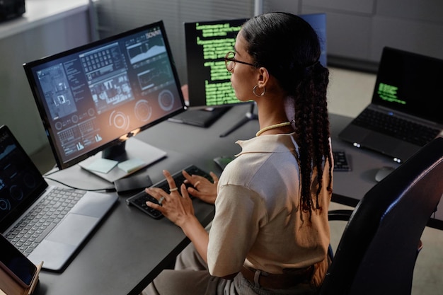 Young female it engineer typing on computer working in it company office