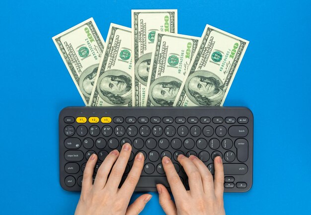 Young freelancer making money at home freelance concept Wireless keyboard and money dollar bills Work at home easy job concept Flat lay design top view and copy space photo