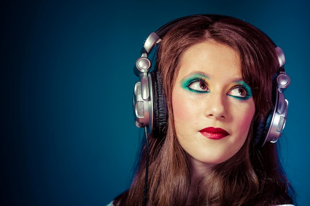 young girl listening music with huge headphones