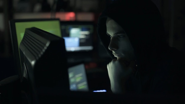 young hacker connecting online with his computer