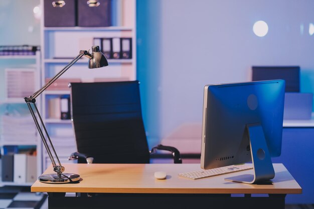 Young pensive asian man working late concentrated and serious in front of computer at night in dark office Late night working or studying concept