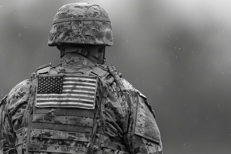 A camouflaged us military uniform with a flag patch on the back black and white photo