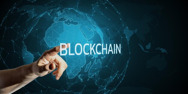 a hand touching the word blockchain with a digital world map in the background representing the concept of global technology