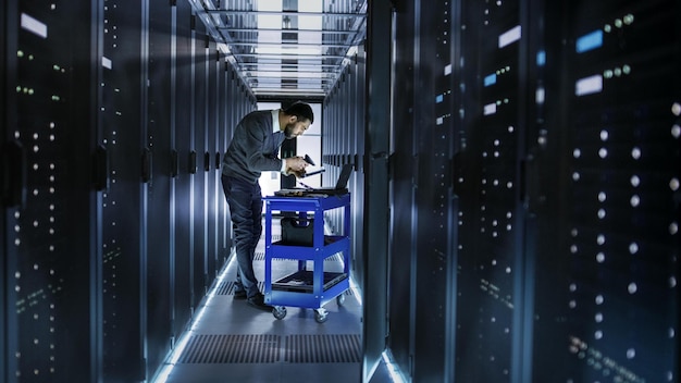 A man stands in a server room with a cart that says'it's time to go to work '