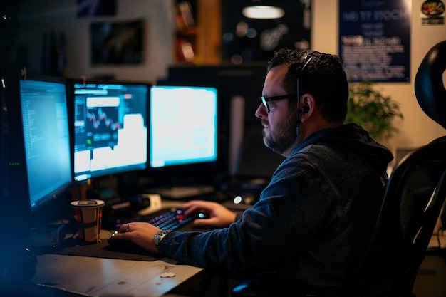 a man with glasses on and a keyboard with a cup of coffee in front of him