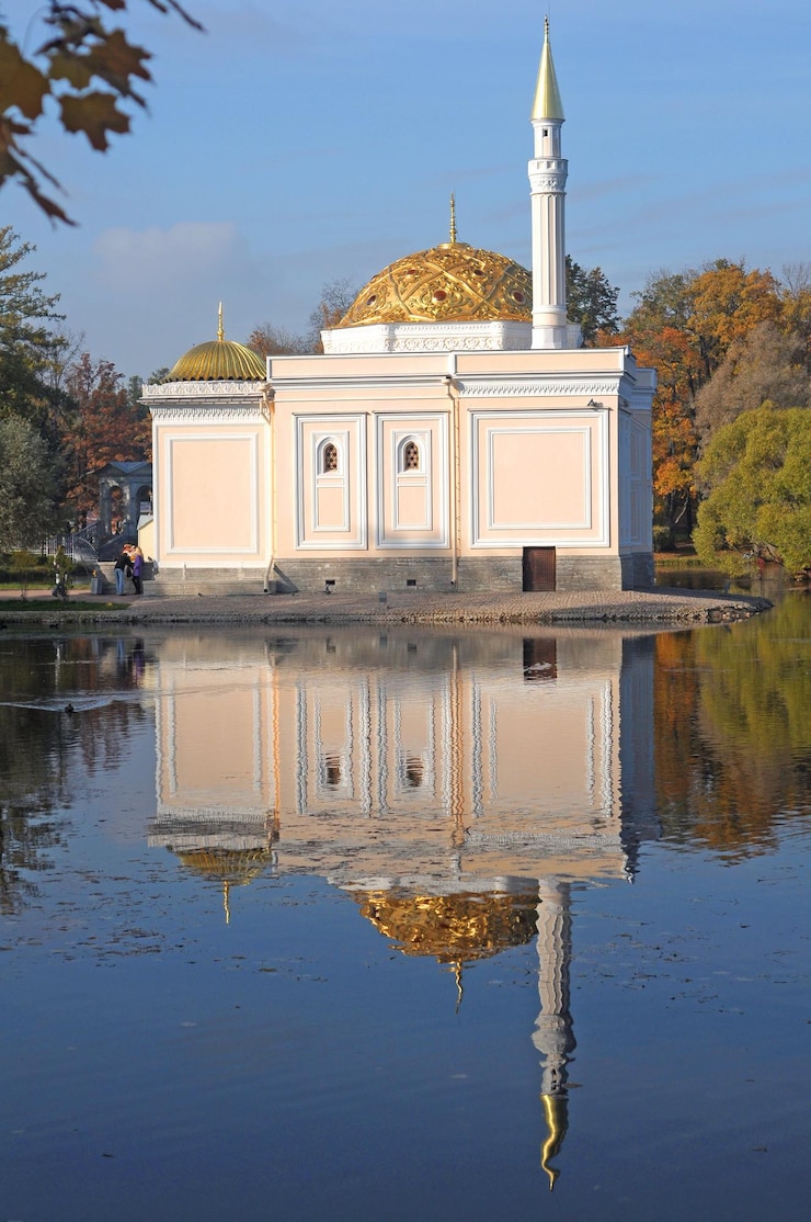 Fotoğraf a mosque in the water with a golden dome on the top.